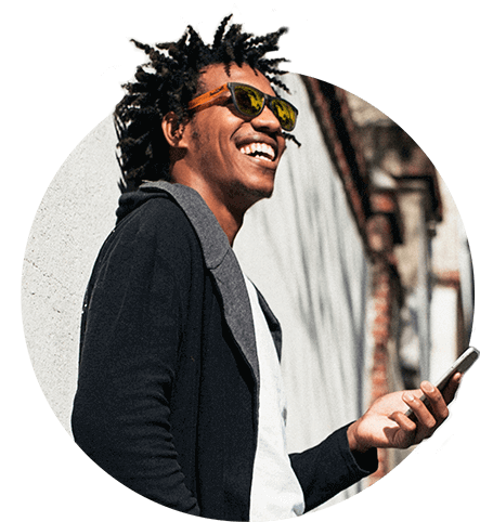 man wearing black jacket and sunglasses holding mobile phone