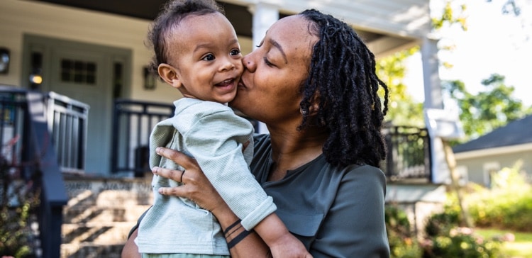 Image of a woman kissing her child